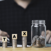 Accountants make accounts, income, expenses, annually to calculate taxation with coins stacking and saving jar for tax reduce and refund concept.