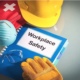 a hard hat, safety glasses, safety gloves and a workplace safety book