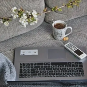 a laptop computer sitting on top of a couch next to a cup of coffee