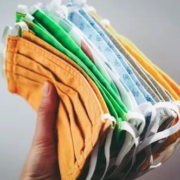 a person holding a bunch of cloth masks