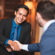 a man shaking hands with another man in a suit